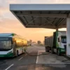 Green hydrogen vehicles pilot India — hydrogen fuel-cell bus and hydrogen truck refuelling at a highway hydrogen station