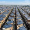 Aerial view of Indian residential rooftops covered in solar panels, illustrating PM Surya Ghar's 50 lakh households milestone
